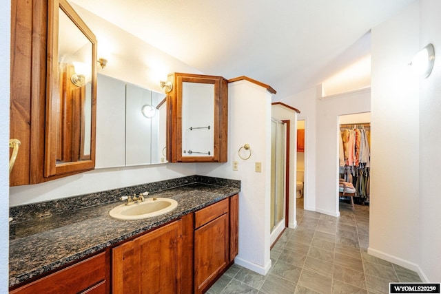 94 Upper Clear Creek Rd, Buffalo, WY 82834 - bathroom with vanity, lofted ceiling, a spacious closet, toilet, and baseboards