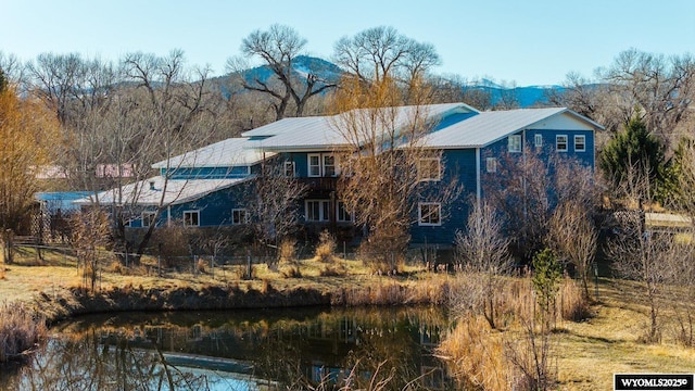 94 Upper Clear Creek Rd, Buffalo, WY 82834 - rear view of property featuring a water and mountain view, metal roof, and fence