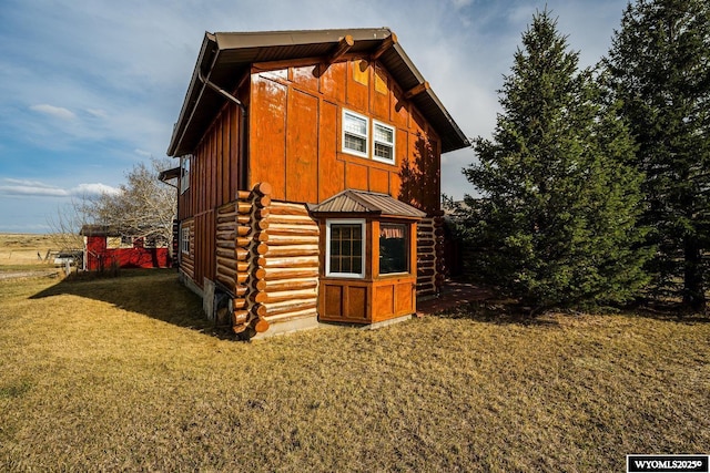 view of side of home featuring a lawn and log exterior