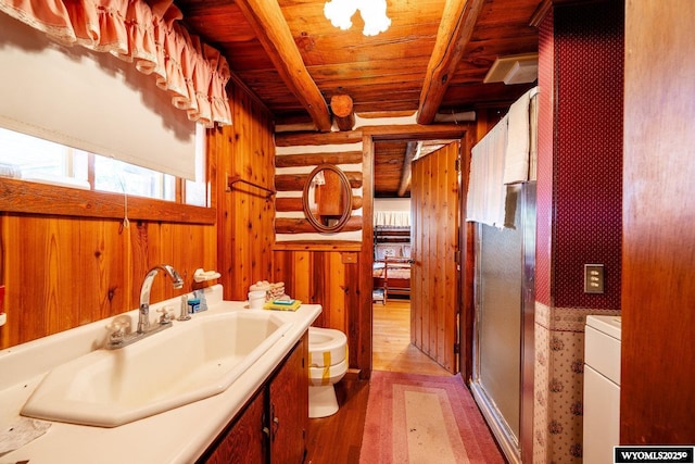 bathroom featuring vanity, toilet, wooden ceiling, log walls, and a shower stall