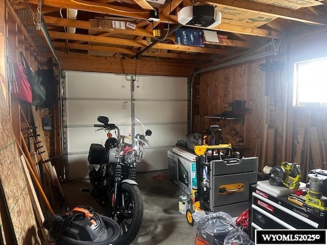 garage with a garage door opener and wooden walls