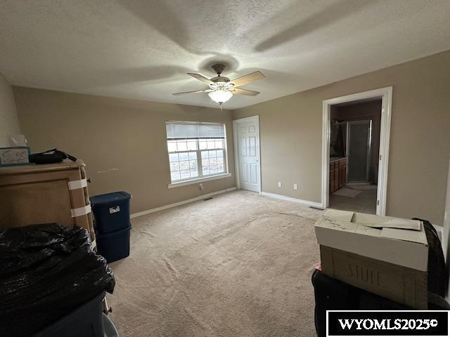 bedroom with a textured ceiling, baseboards, ceiling fan, connected bathroom, and carpet floors