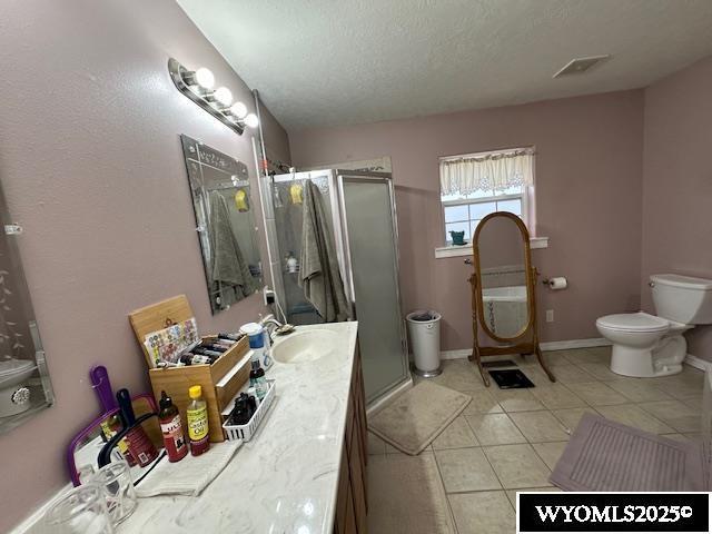 full bathroom with toilet, tile patterned flooring, vanity, and a shower stall