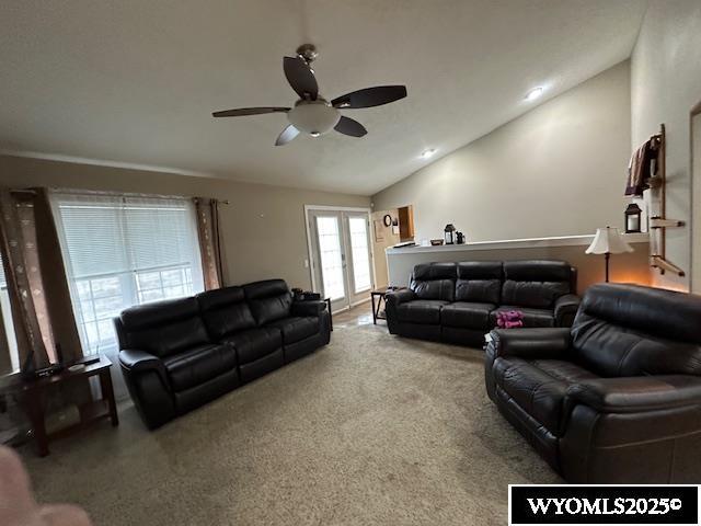 carpeted living room with lofted ceiling and ceiling fan