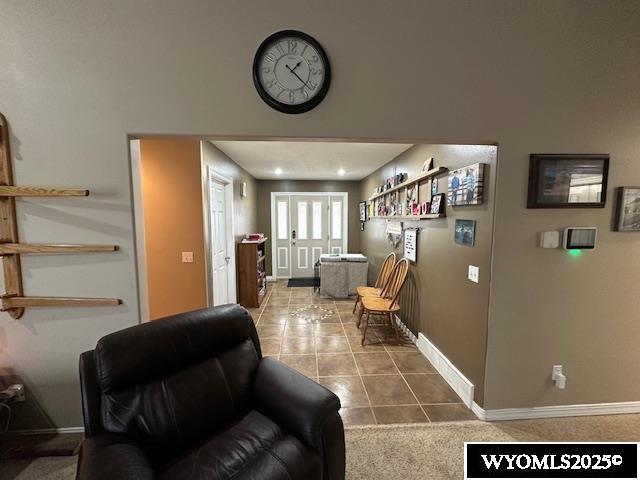 tiled living room featuring baseboards and french doors