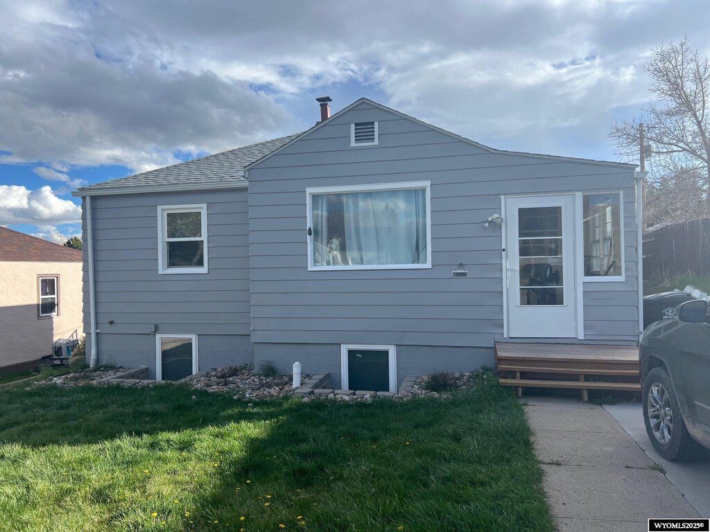 rear view of house with a lawn and entry steps