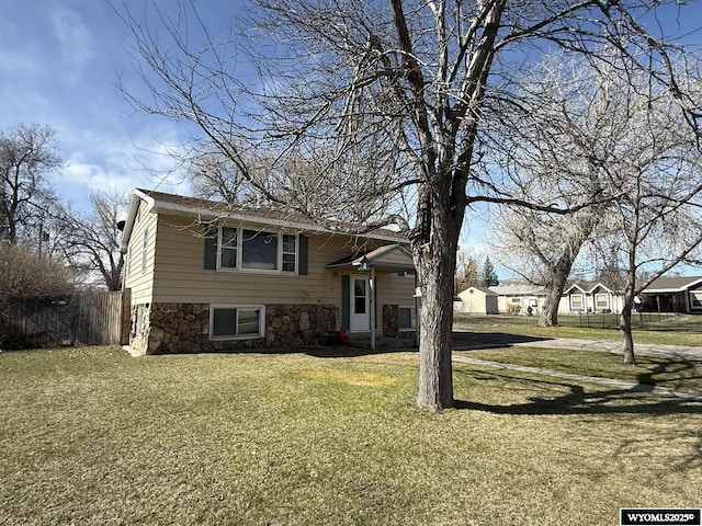 655 Amoretti St, Lander, WY 82520 - split level home featuring stone siding, fence, and a front lawn