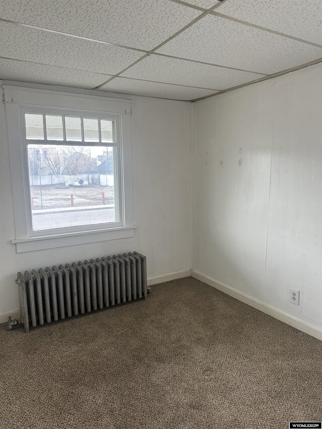 214 M St, Rock Springs, WY 82901 - carpeted empty room with baseboards, radiator heating unit, and a paneled ceiling