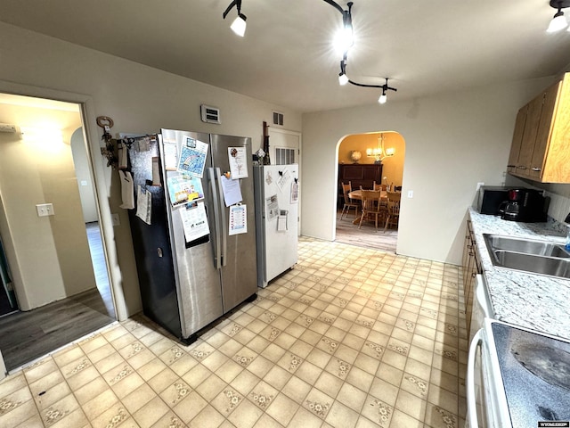 2842 Main St, Torrington, WY 82240 - kitchen featuring arched walkways, visible vents, a sink, and freestanding refrigerator