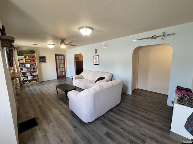 2842 Main St, Torrington, WY 82240 - living area featuring arched walkways, dark wood-style floors, ceiling fan, and visible vents