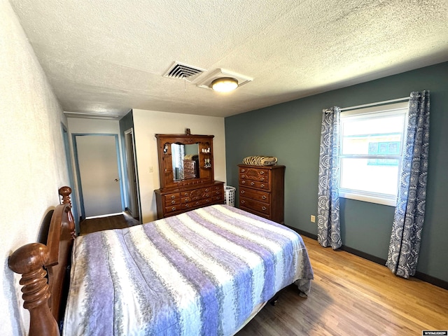 2842 Main St, Torrington, WY 82240 - bedroom with baseboards, visible vents, wood finished floors, and a textured ceiling
