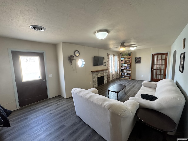 2842 Main St, Torrington, WY 82240 - living room featuring a textured ceiling, visible vents, wood finished floors, and a fireplace