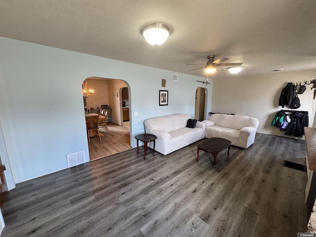 2842 Main St, Torrington, WY 82240 - living area with a textured ceiling, arched walkways, visible vents, a ceiling fan, and wood finished floors