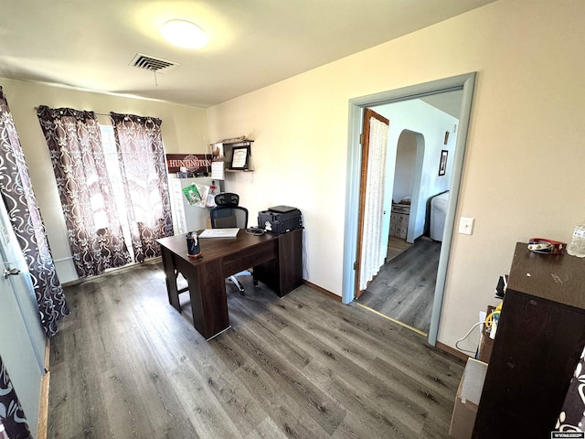 2842 Main St, Torrington, WY 82240 - home office with wood finished floors, arched walkways, baseboards, and visible vents