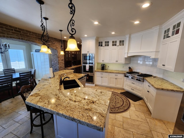 303 Tamarack Dr, Rock Springs, WY 82901 - kitchen with premium range hood, stone tile floors, a sink, and appliances with stainless steel finishes