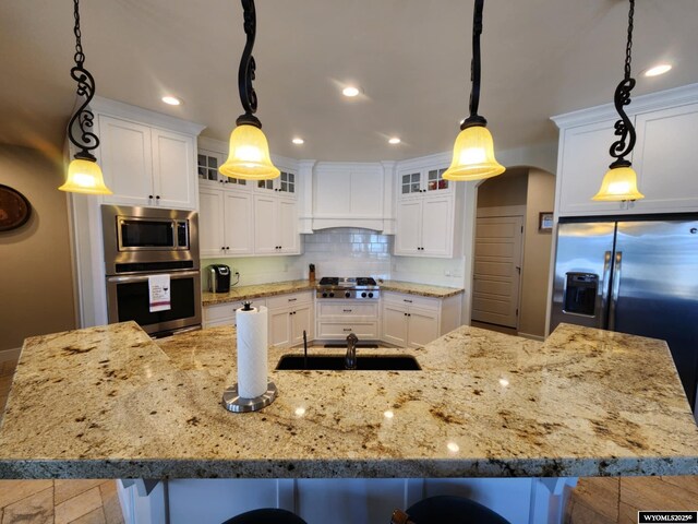 303 Tamarack Dr, Rock Springs, WY 82901 - kitchen featuring a kitchen bar, stainless steel appliances, premium range hood, tasteful backsplash, and a spacious island
