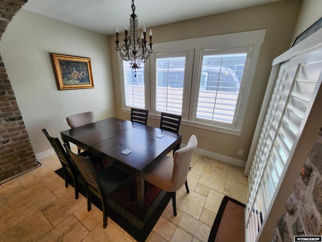 303 Tamarack Dr, Rock Springs, WY 82901 - dining area featuring baseboards, stone tile flooring, and an inviting chandelier