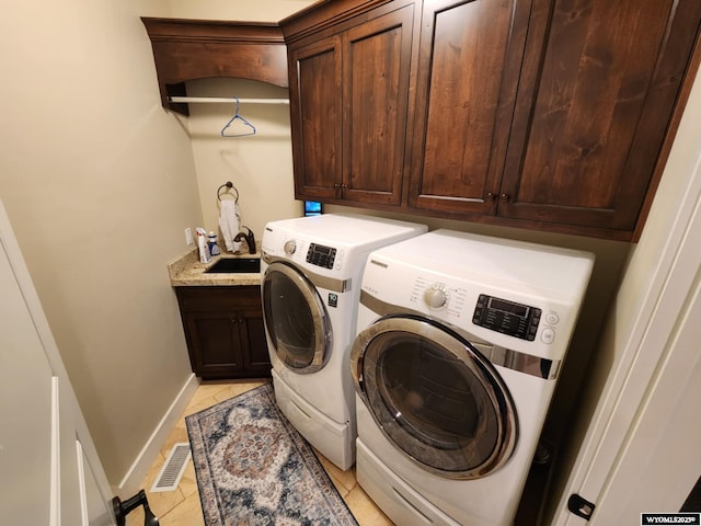 303 Tamarack Dr, Rock Springs, WY 82901 - washroom with light tile patterned flooring, visible vents, a sink, washer and dryer, and cabinet space