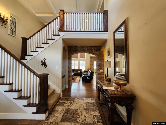 303 Tamarack Dr, Rock Springs, WY 82901 - entrance foyer featuring baseboards, wood finished floors, stairway, arched walkways, and a high ceiling