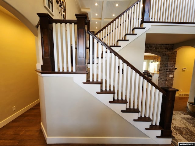 303 Tamarack Dr, Rock Springs, WY 82901 - staircase with arched walkways, baseboards, a high ceiling, and wood finished floors