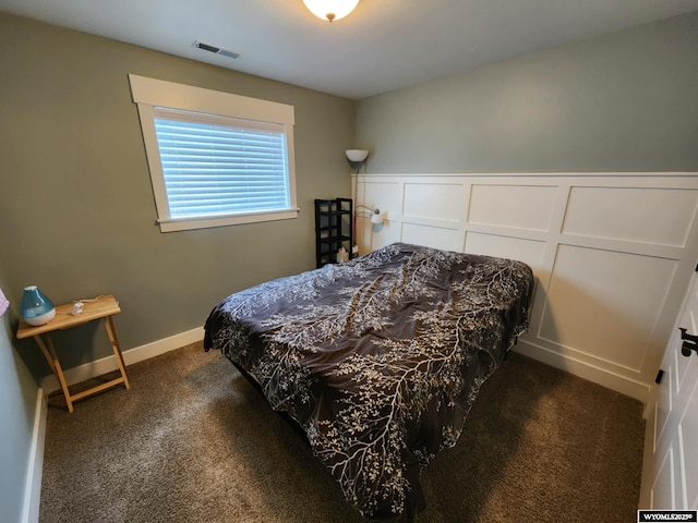 303 Tamarack Dr, Rock Springs, WY 82901 - bedroom featuring carpet flooring, a decorative wall, a wainscoted wall, and visible vents