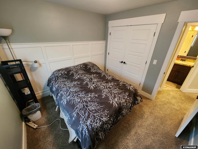 303 Tamarack Dr, Rock Springs, WY 82901 - carpeted bedroom featuring a decorative wall, a closet, and wainscoting