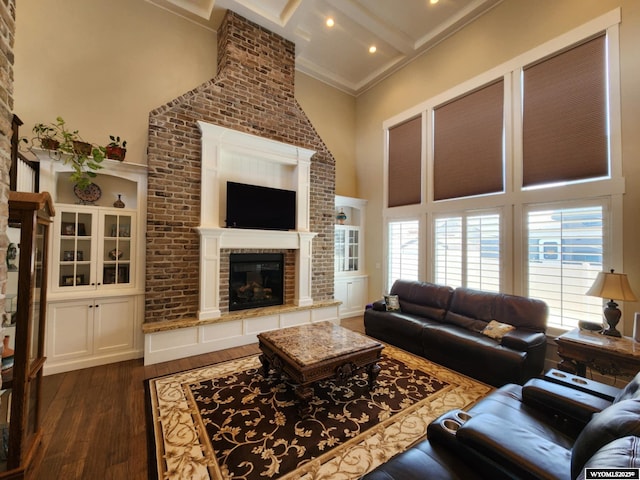 303 Tamarack Dr, Rock Springs, WY 82901 - living area with dark wood-style flooring, ornamental molding, a towering ceiling, beam ceiling, and a brick fireplace
