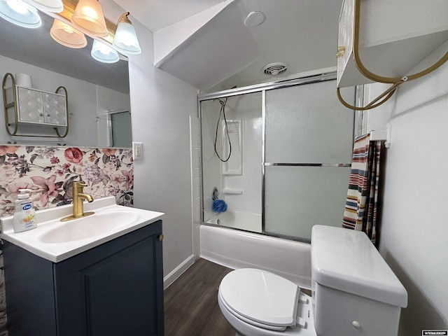 bathroom featuring toilet, vanity, wood finished floors, enclosed tub / shower combo, and visible vents