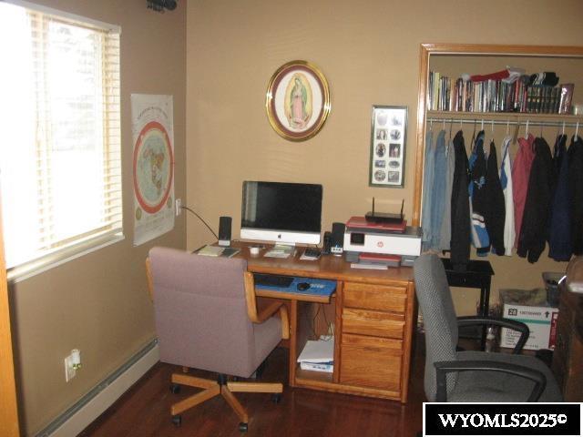office with wood finished floors and a baseboard heating unit