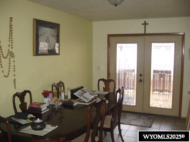 dining room with french doors and light tile patterned floors