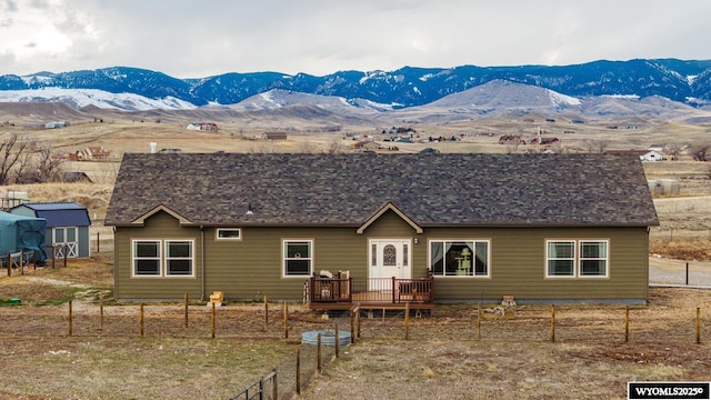 rear view of property with fence and a deck with mountain view