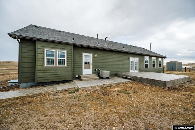 back of house featuring a patio, central AC, a storage unit, an outbuilding, and french doors