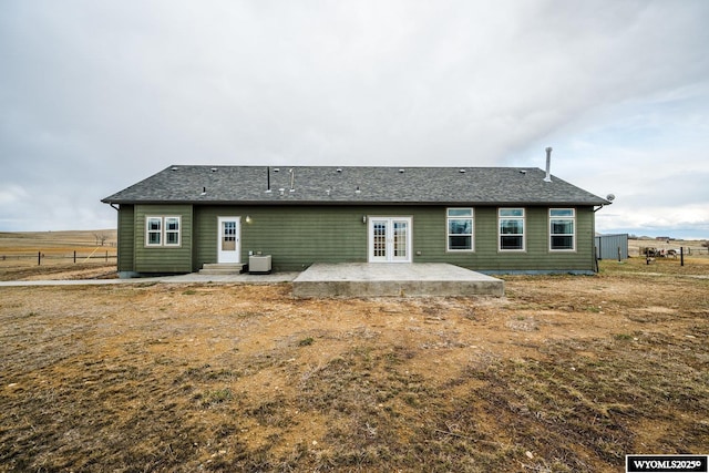 back of property with french doors, roof with shingles, fence, entry steps, and a patio