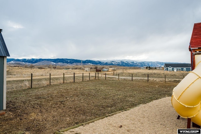 view of yard featuring a mountain view, fence, and a rural view