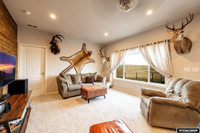 living area featuring visible vents, recessed lighting, and light carpet