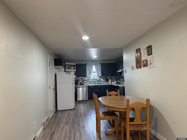 dining space featuring baseboard heating, baseboards, and wood finished floors