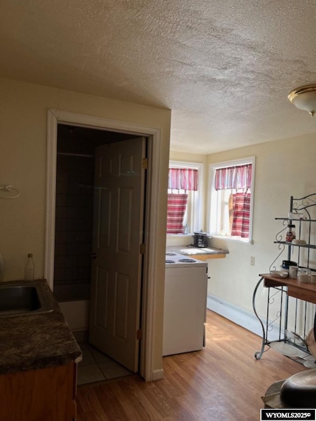 419 6th St, Rawlins, WY 82301 - interior space with a textured ceiling, washer / clothes dryer, a sink, and light wood-style floors