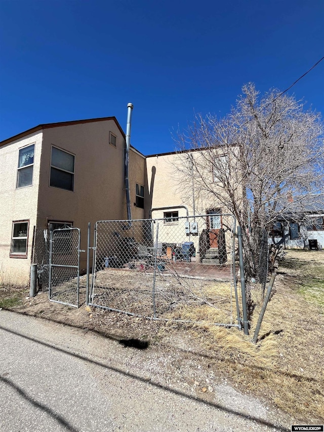 419 6th St, Rawlins, WY 82301 - view of property exterior featuring a gate, stucco siding, and fence