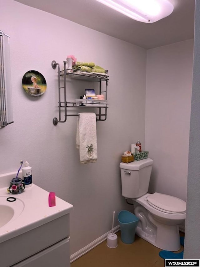 419 6th St, Rawlins, WY 82301 - bathroom featuring toilet, vanity, and baseboards