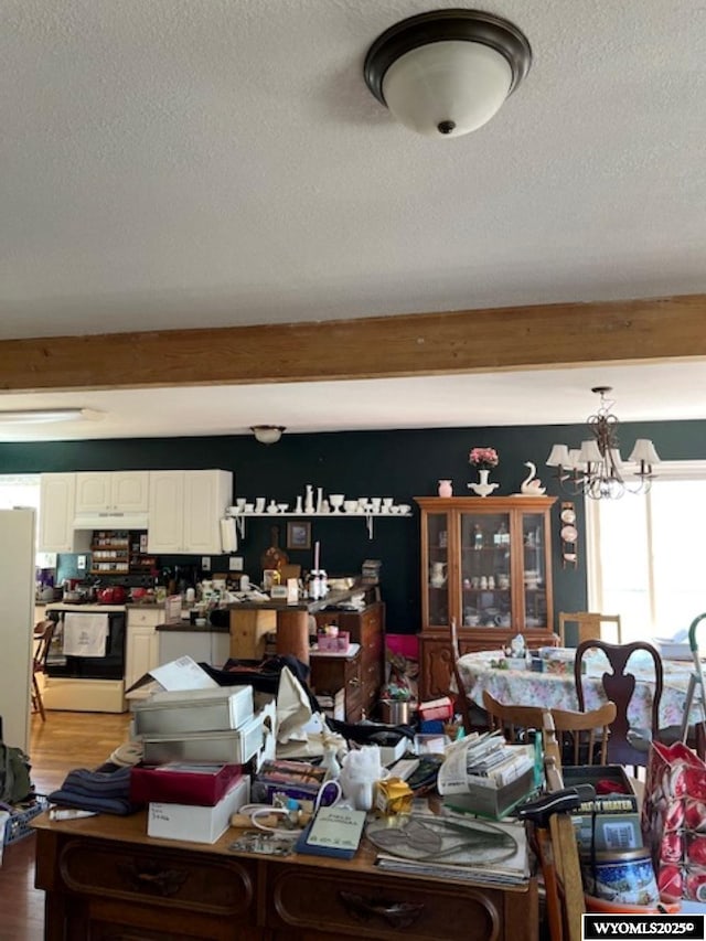 419 6th St, Rawlins, WY 82301 - dining space featuring a textured ceiling, wood finished floors, a chandelier, and beamed ceiling