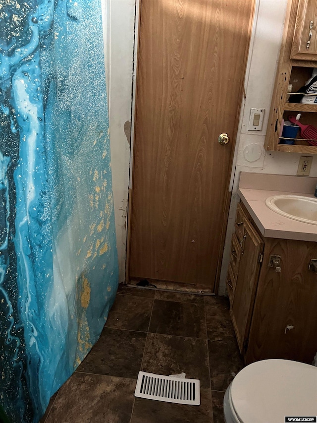 305 E Center St, Rawlins, WY 82301 - full bathroom featuring vanity, a shower with curtain, toilet, visible vents, and stone finish flooring