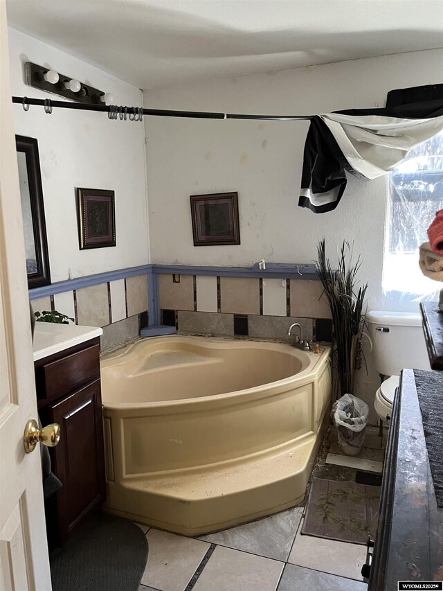 305 E Center St, Rawlins, WY 82301 - full bathroom with tile patterned floors, vanity, a bath, and toilet