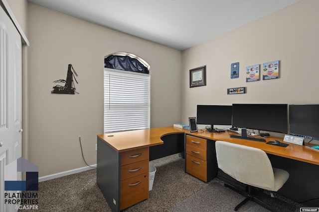 office space with dark carpet and baseboards