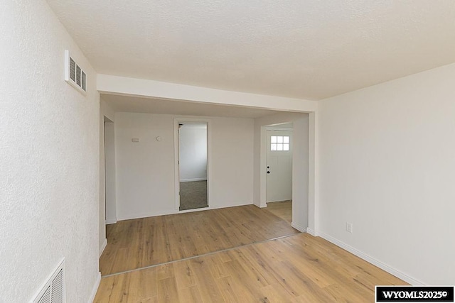 630 Ludvig St, Rock Springs, WY 82901 - empty room featuring light wood-style floors, baseboards, visible vents, and a textured ceiling