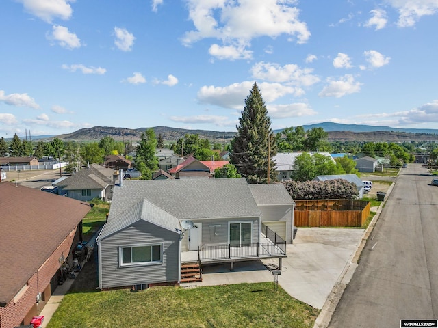 432 15th St, Evanston, WY 82930 - view of front of home with a mountain view, concrete driveway, roof with shingles, and a residential view