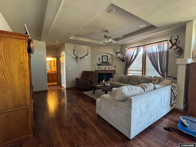2720 State Highway 414 N, Lyman, WY 82937 - living area with ceiling fan, dark wood finished floors, a raised ceiling, and a fireplace