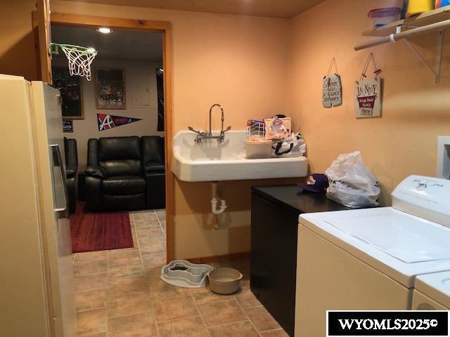 816 Center St, Rock Springs, WY 82901 - washroom with laundry area, separate washer and dryer, light tile patterned floors, and a sink