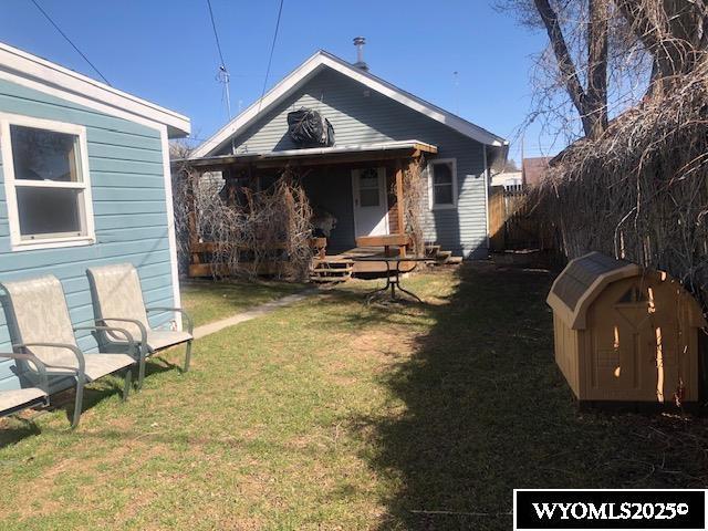 816 Center St, Rock Springs, WY 82901 - rear view of house featuring a yard, a storage unit, fence, and an outdoor structure