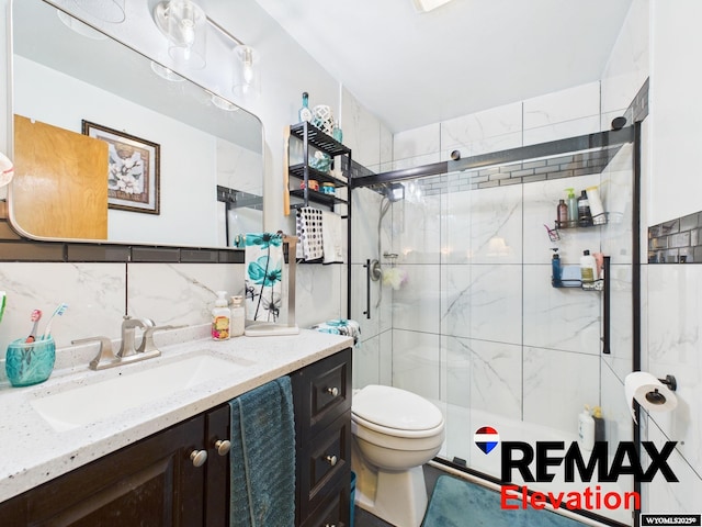 707 S 6th St, Basin, WY 82410 - bathroom featuring vanity, toilet, tile walls, a stall shower, and decorative backsplash