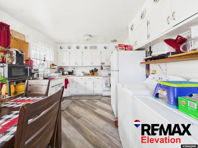 707 S 6th St, Basin, WY 82410 - kitchen featuring white appliances, light wood-type flooring, separate washer and dryer, white cabinets, and light countertops